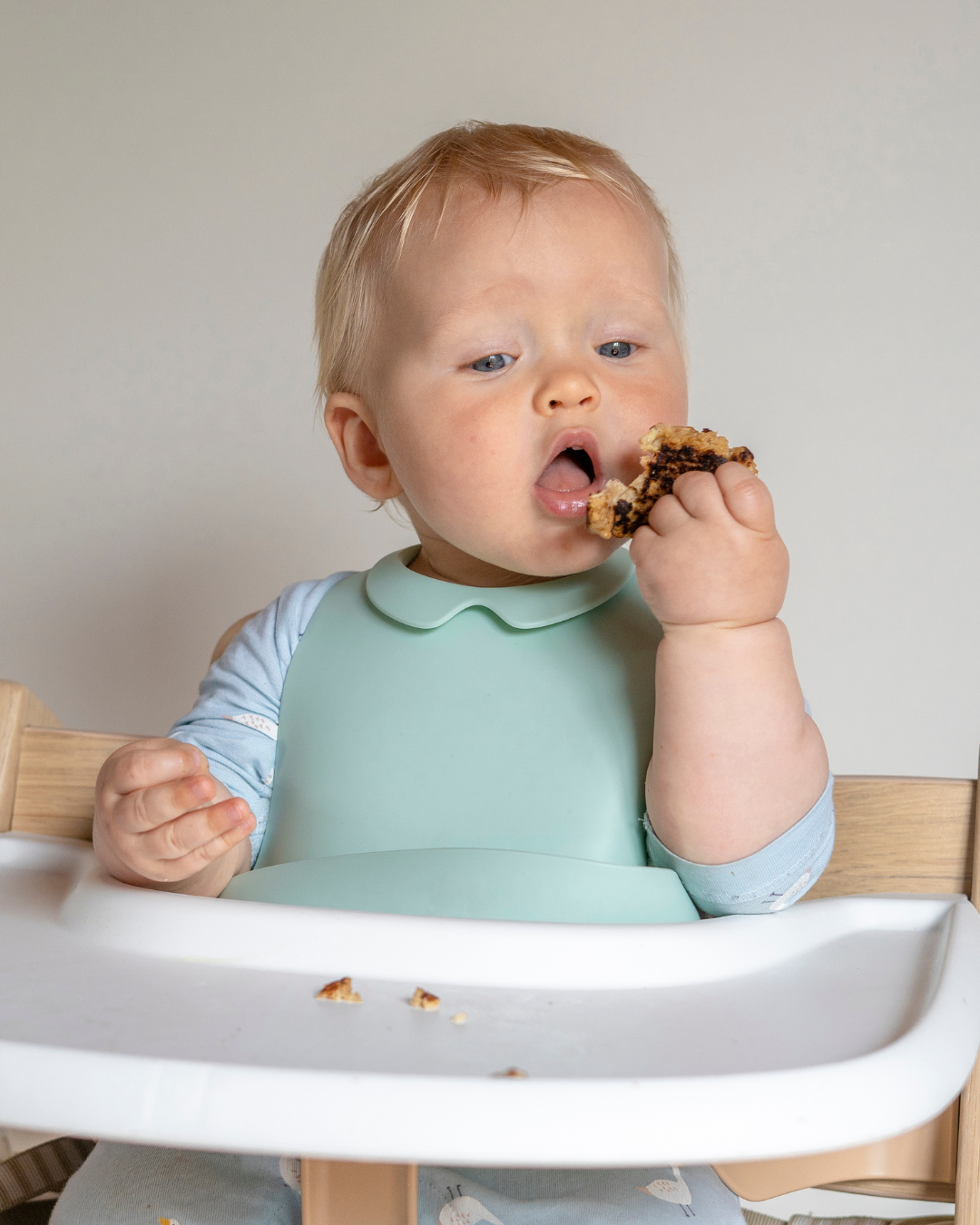 Bébé qui mange seul en chaise haute